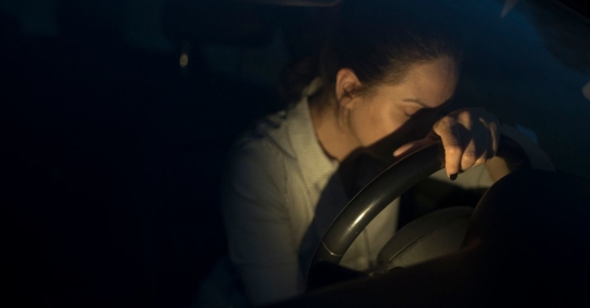 Woman slumped over car steering wheel after she was charged with a DUI