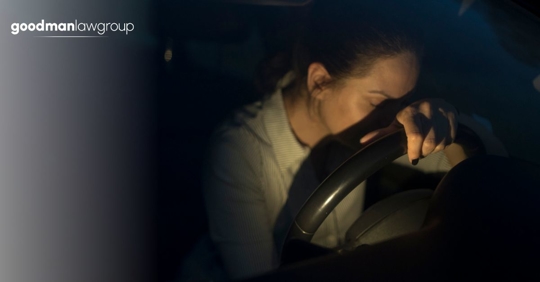woman leaning over steering wheel
