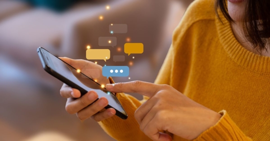 Hand of young woman using smartphone for chat and communication.