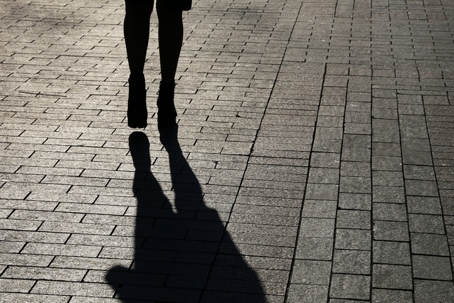 Person in the dark with their shadow in the foreground