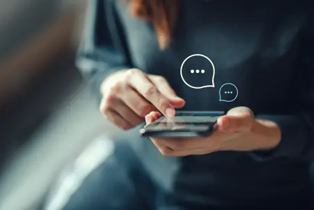 Women's hand typing on mobile smartphone